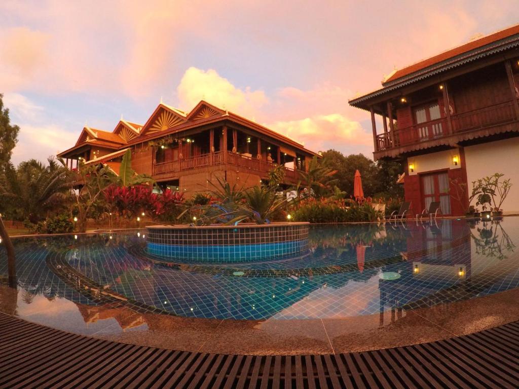 a large swimming pool in front of a house at Sunbird Garden Resort in Sihanoukville