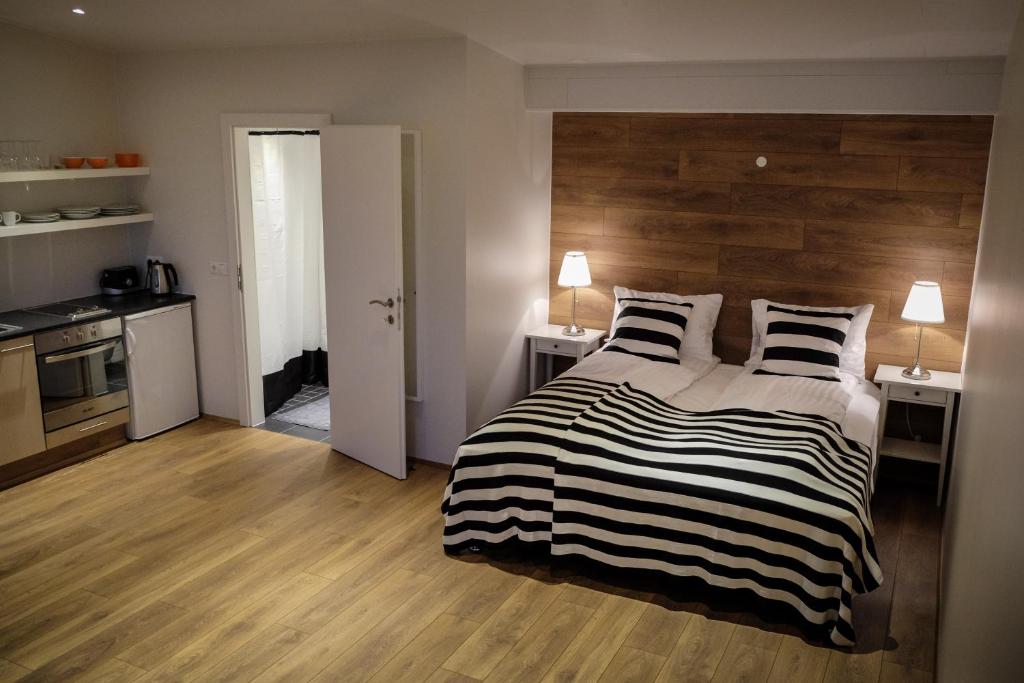 1 dormitorio con 1 cama con cabecero de madera en Thoristun Apartments en Selfoss