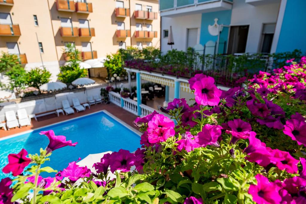 un balcón con piscina y flores en Hotel Villa dei Fiori - sul mare con piscina en Rímini