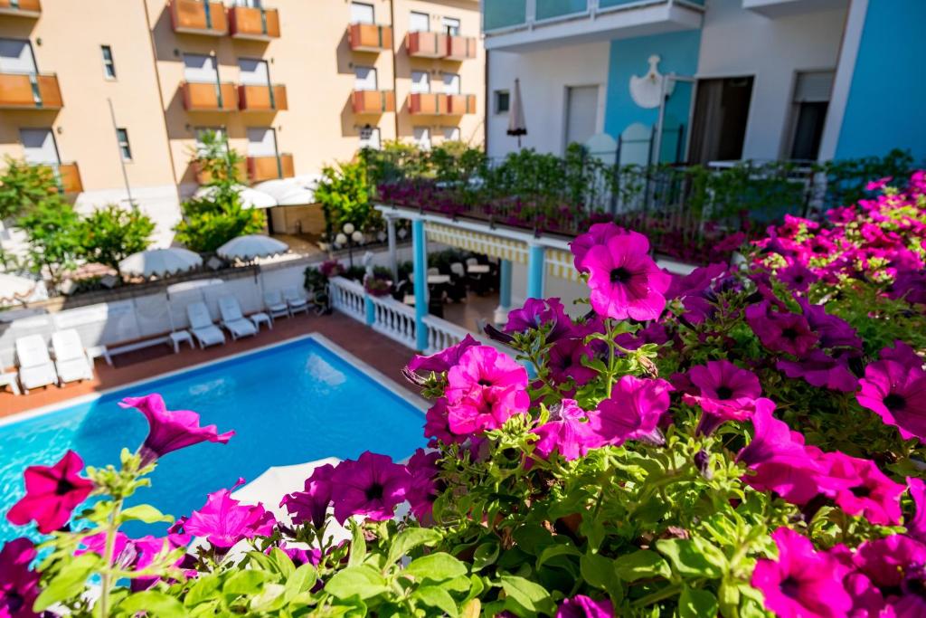a balcony with a swimming pool and flowers at Hotel Villa dei Fiori - sul mare con piscina in Rimini