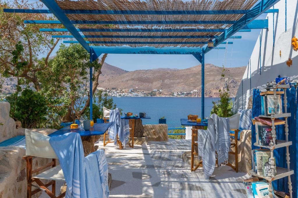 a patio with tables and chairs and a view of the water at Antoniadi Rooms in Livadia