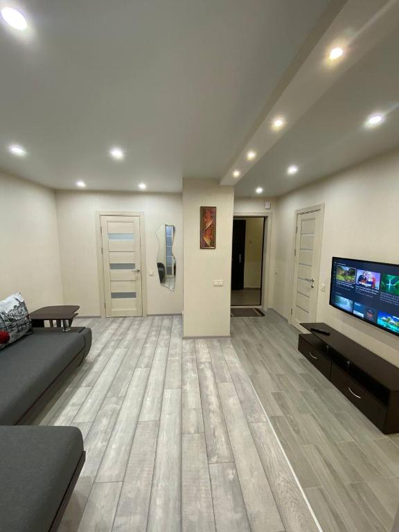 a living room with a couch and a flat screen tv at Замечательная евродвушка район Теремков 209 in Teremki