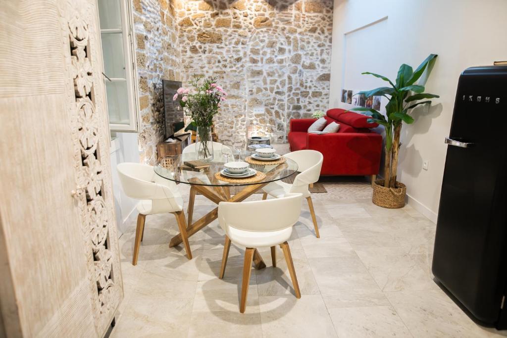 een eetkamer met een tafel en witte stoelen bij innCádizCASA SEÑORIAL DE 1790 in Cádiz