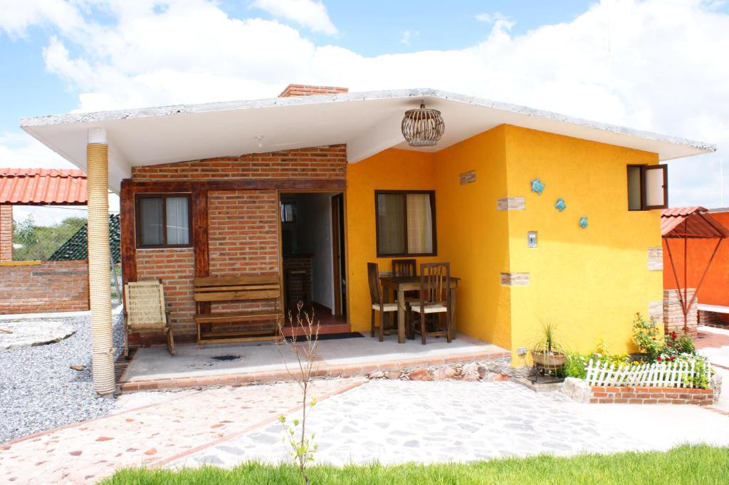 une maison jaune avec un toit blanc dans l'établissement Villas La Bisnaga, à Bernal