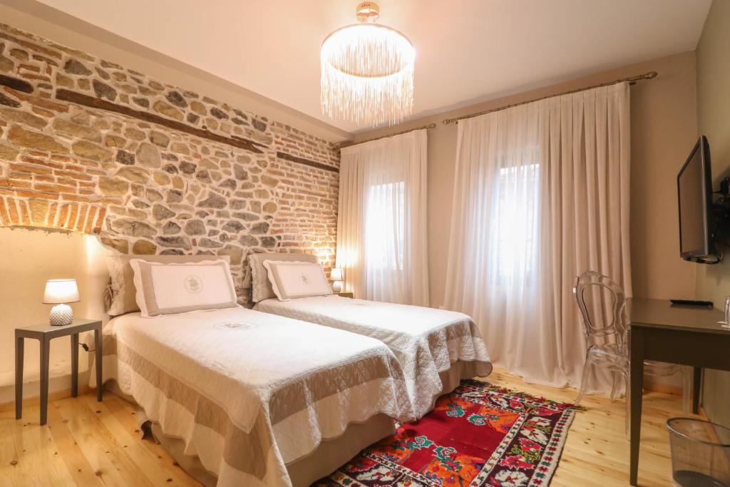 - une chambre avec un lit et un mur en briques dans l'établissement Në Kroi, à Korçë