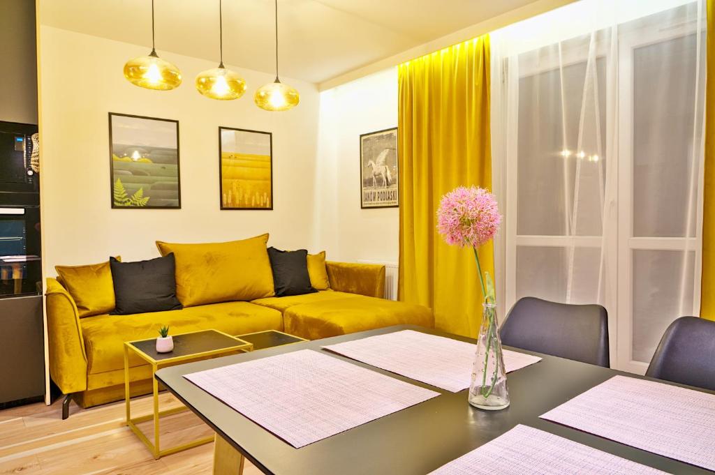 salon z żółtą kanapą i stołem w obiekcie Apartament Alina 25 w Białej Podlaskiej