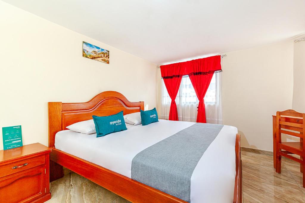 a bedroom with a bed and a window with red curtains at Ayenda Onix Suite in Pasto
