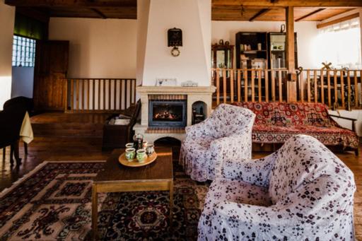 een woonkamer met twee stoelen en een open haard bij Casa Adelina in Valea Lungă-Cricov
