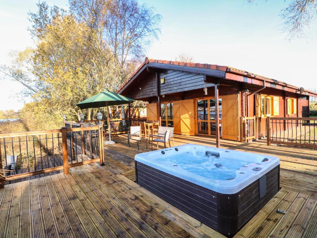 a hot tub on the deck of a house at Osprey Lodge in Tattershall