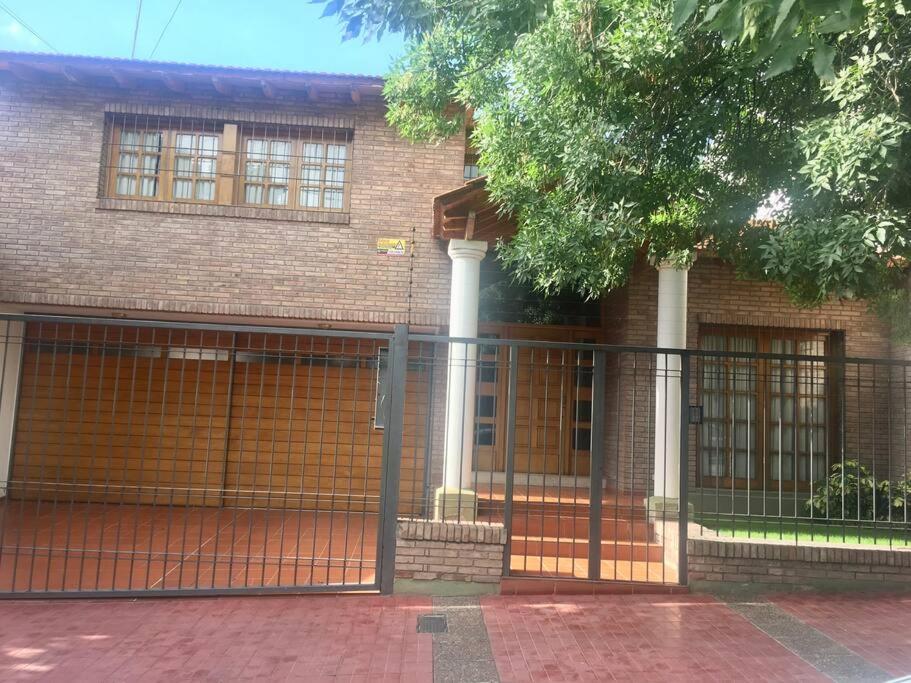 a brick house with a gate in front of it at Casa Mendoza Capital cerca del Parque y Centro in La Cieneguita