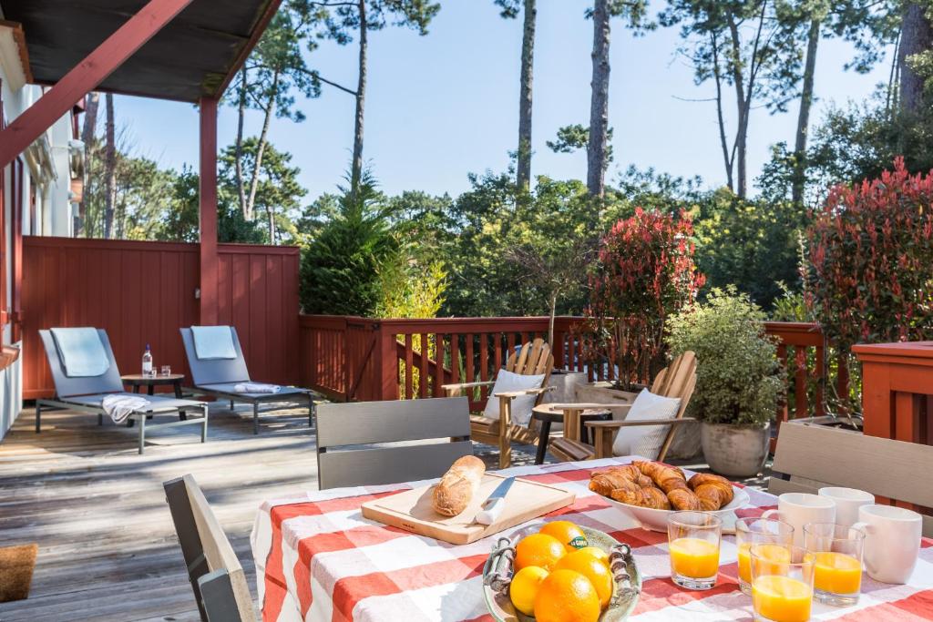 a table with a plate of food on a patio at Hâvre de paix sous les pins, au coeur des Abatilles, avec sa superbe terrasse in Arcachon