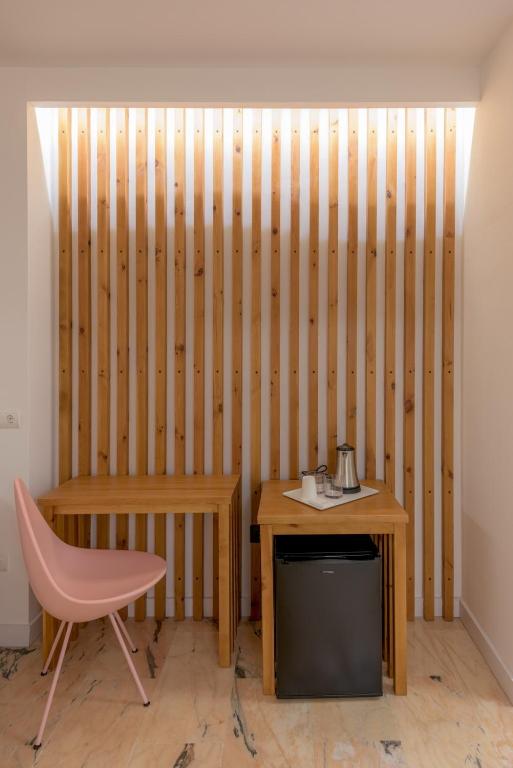 a room with a wooden wall with a desk and a chair at Hotel Boutique Sibarys - Adults Recommended in Nerja