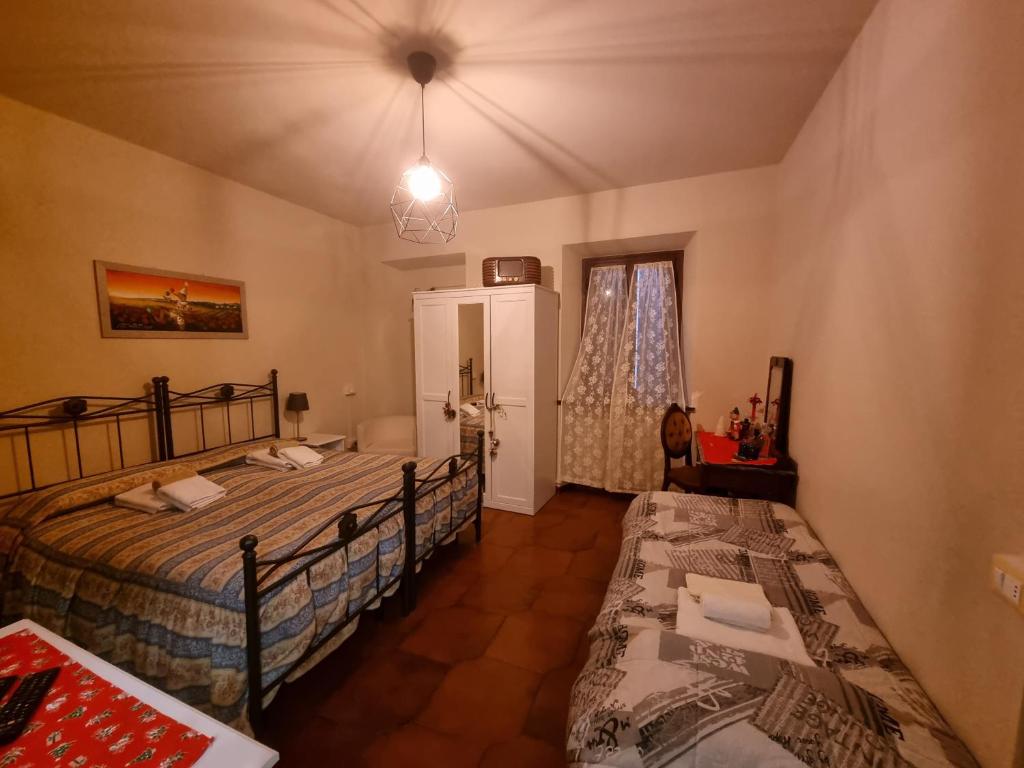 1 Schlafzimmer mit 2 Einzelbetten und einem Fenster in der Unterkunft A Collodi Io & Mamma in Collodi