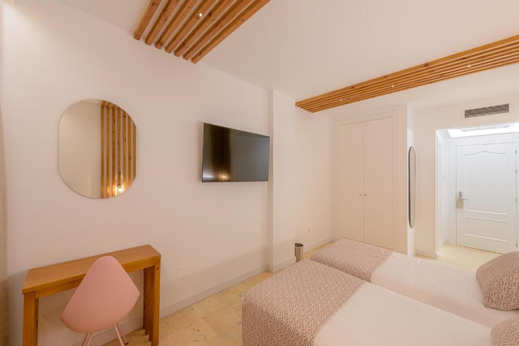 a bedroom with a bed and a desk and a mirror at Hotel Boutique Sibarys - Adults Recommended in Nerja