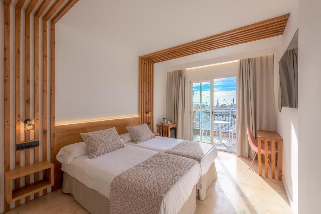 a hotel room with a bed and a balcony at Hotel Boutique Sibarys - Adults Recommended in Nerja