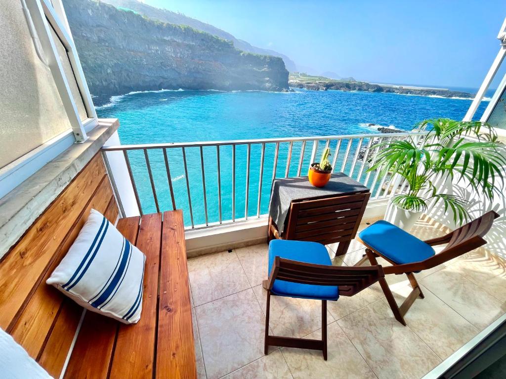 a balcony with a table and chairs and the ocean at Mundo Beach House, Playa San Marcos, Tenerife in Icod de los Vinos