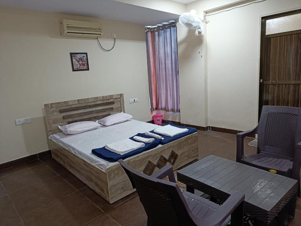1 dormitorio con 1 cama, 1 mesa y 1 silla en Bliss Rooms en Alibaug