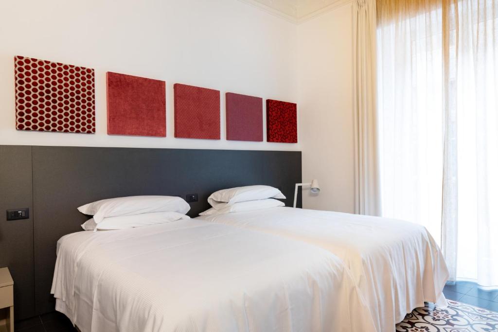 Postel nebo postele na pokoji v ubytování Riflessi Acireale Palace Suites
