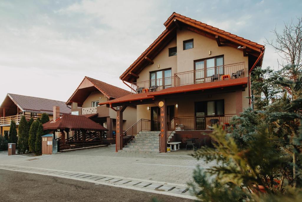 una casa con balcón y escaleras delante en Pensiunea Smiley en Turda