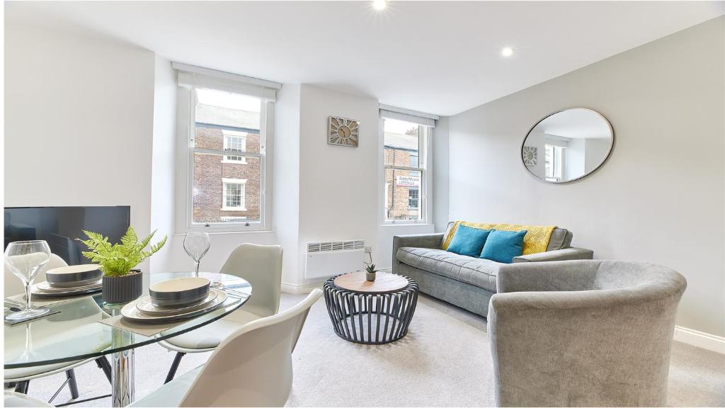 uma sala de estar com uma mesa e um sofá em Roker boutique apartment em Sunderland