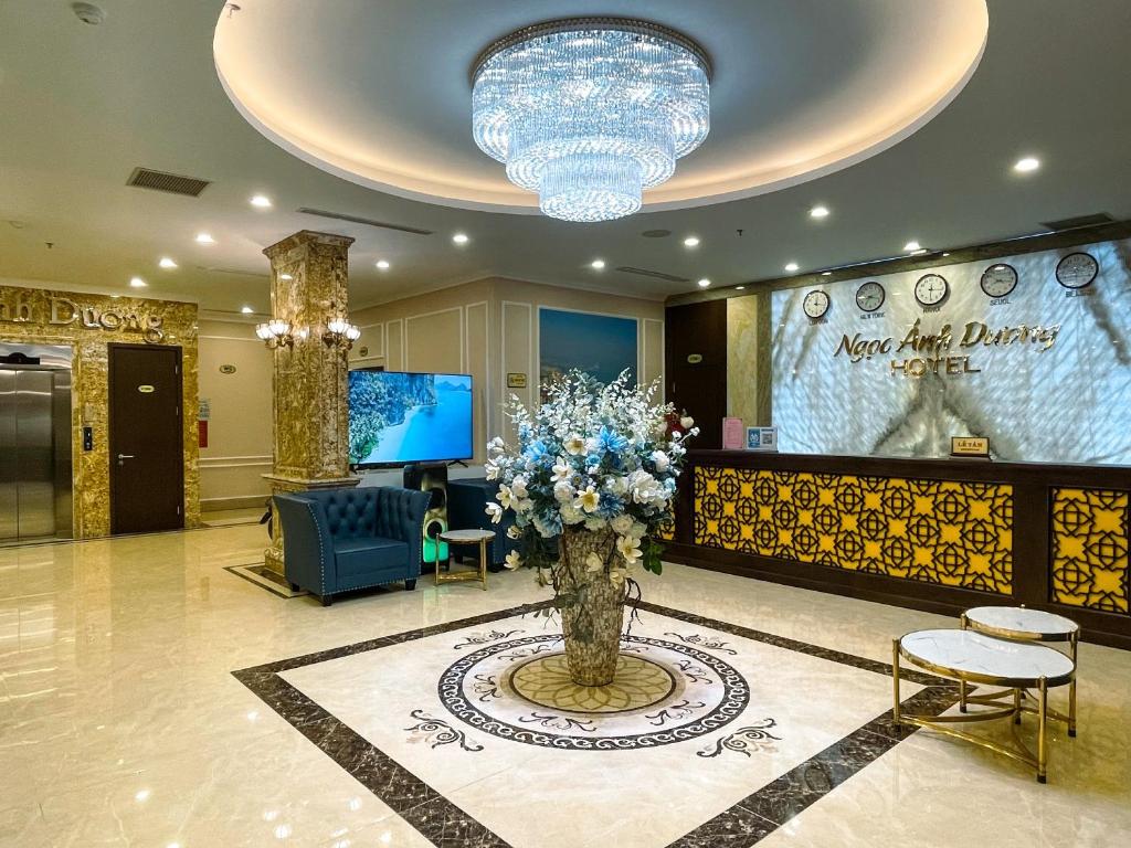 un vestíbulo con un gran jarrón de flores en el medio en Ngọc Ánh Dương Hotel, en Ha Long