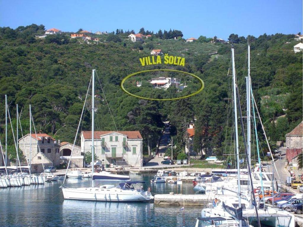 eine Gruppe von Booten, die in einem Yachthafen mit gelbem Schild angedockt sind in der Unterkunft Villa Šolta in Rogač