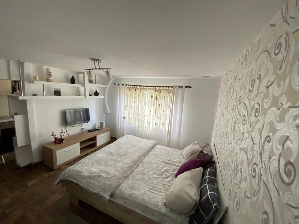 a bedroom with a bed with a large headboard at Garsoniera deosebita intr-o zona linistita Straja-Lupeni in Lupeni