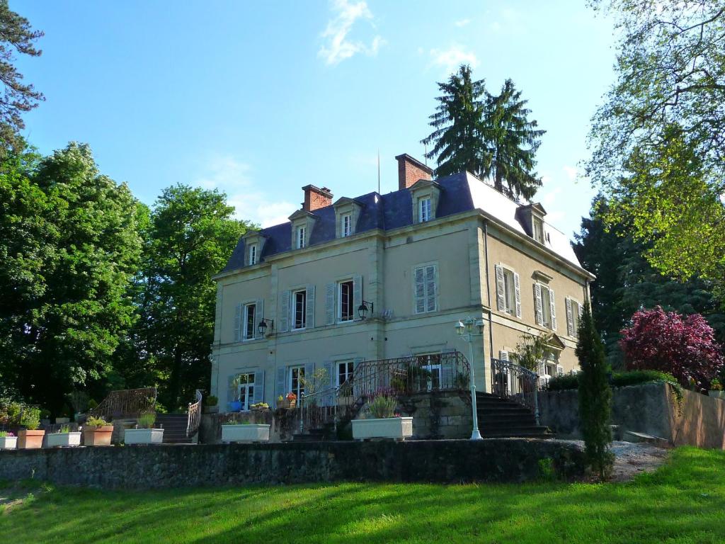 ein großes weißes Haus auf einem Grasfeld in der Unterkunft Château de MontSablé in Lezoux