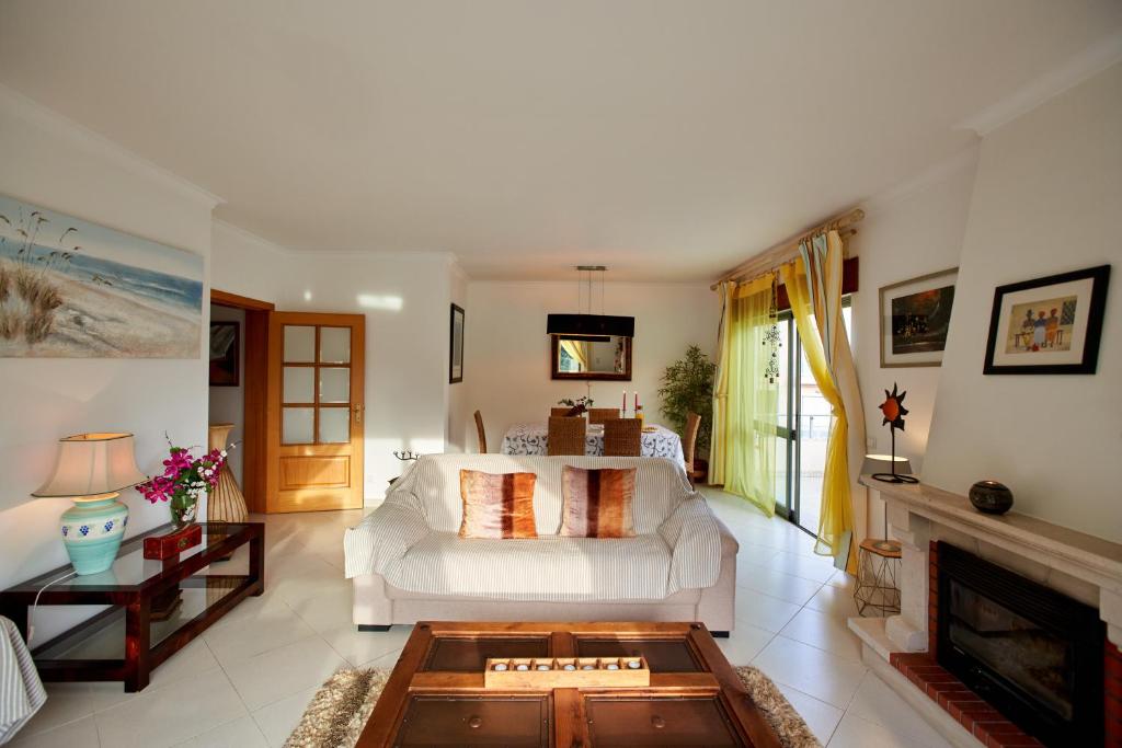 a living room with a white couch and a fireplace at Casa Palames in Sesimbra