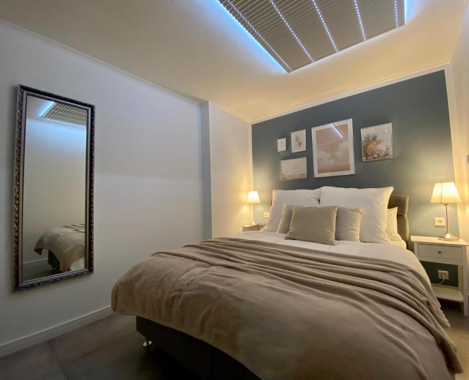 um quarto com uma cama grande e um espelho em Appartement Mond em Senftenberg