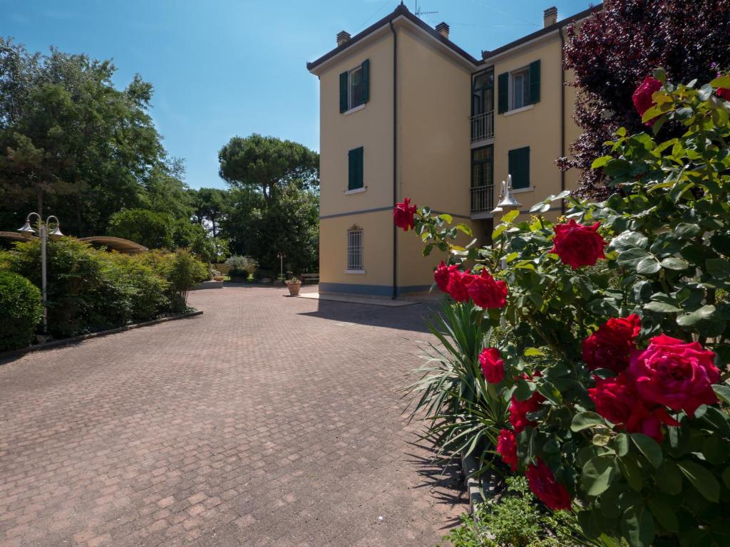 un bâtiment avec des roses rouges devant lui dans l'établissement Villa Bellini, à Porto Garibaldi