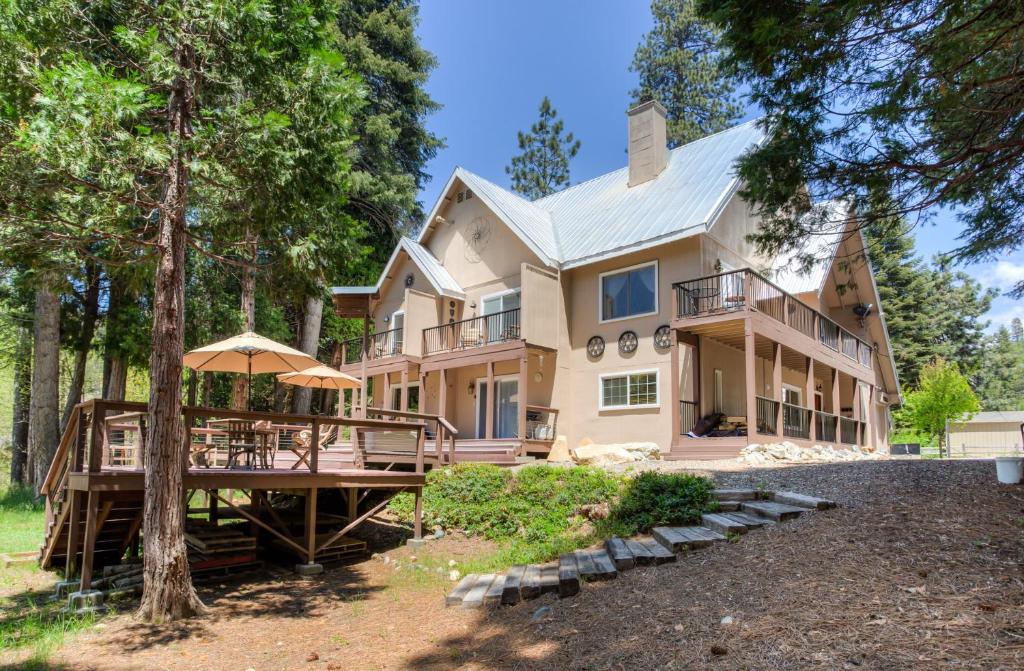 une grande maison avec une terrasse couverte et une terrasse dans l'établissement Big Creek Inn, à Fish Camp