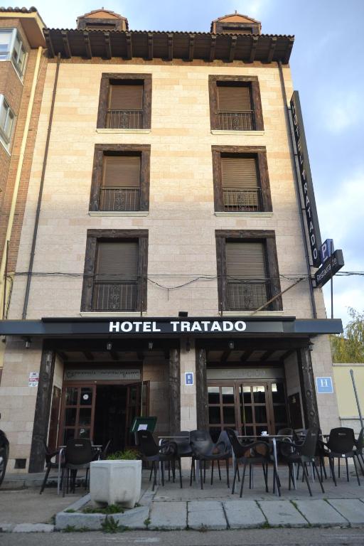 a building with tables and chairs in front of it at Hotel El Tratado in Tordesillas