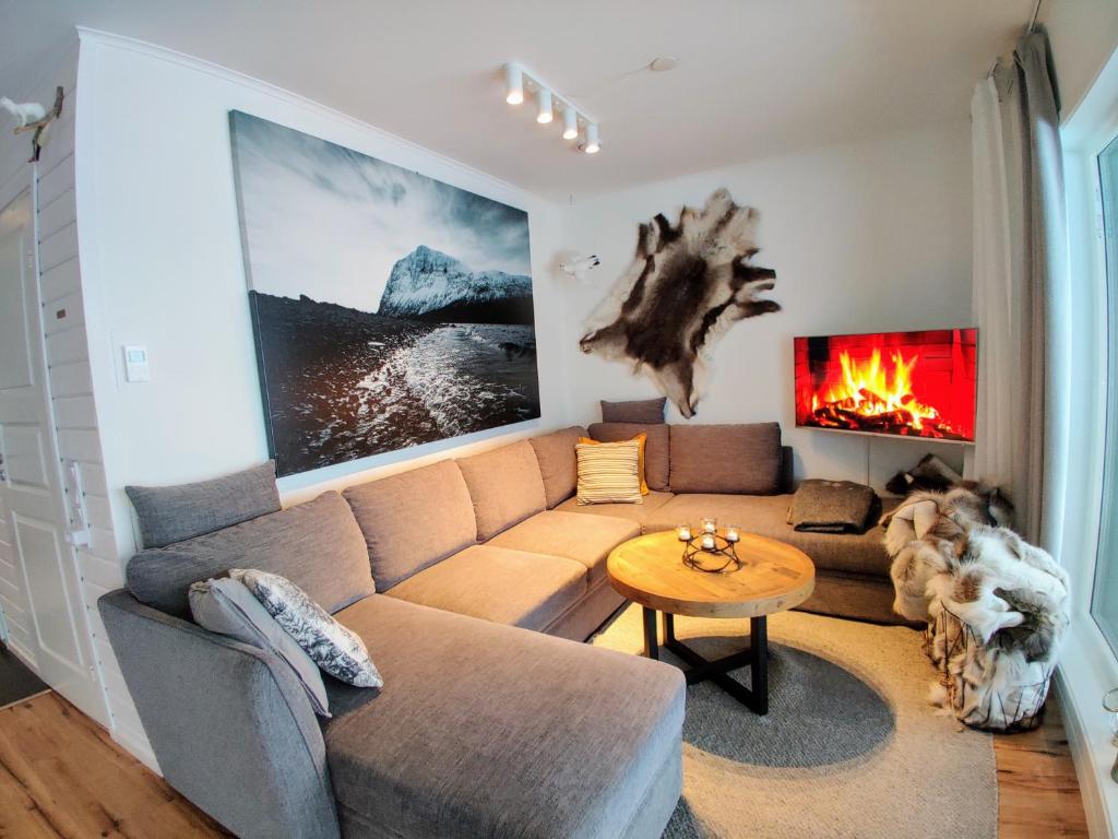 a living room with a couch and a fireplace at Book in Borgafjäll - New cabins for rent at the slalom slope in Borgafjäll
