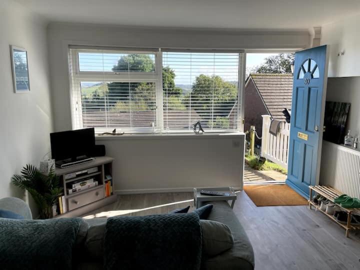 a living room with a couch and a large window at Self-catering studio in beautiful Charmouth in Charmouth