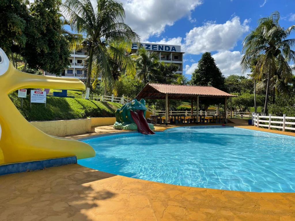 a slide in a swimming pool in a resort at Tijota Hotel Fazenda in Ipatinga