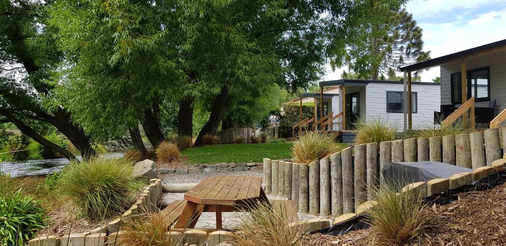 un patio trasero con una mesa de madera y una valla en Spring Creek Holiday Park, en Blenheim