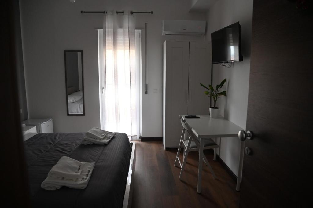 Schlafzimmer mit einem Bett, einem Schreibtisch und einem Fenster in der Unterkunft La Casina B&B in Marina di Schiavonea