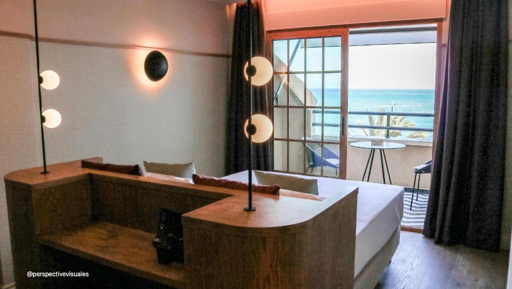 a bedroom with a bed and a view of the ocean at JovA Hotel Boutique in El Campello