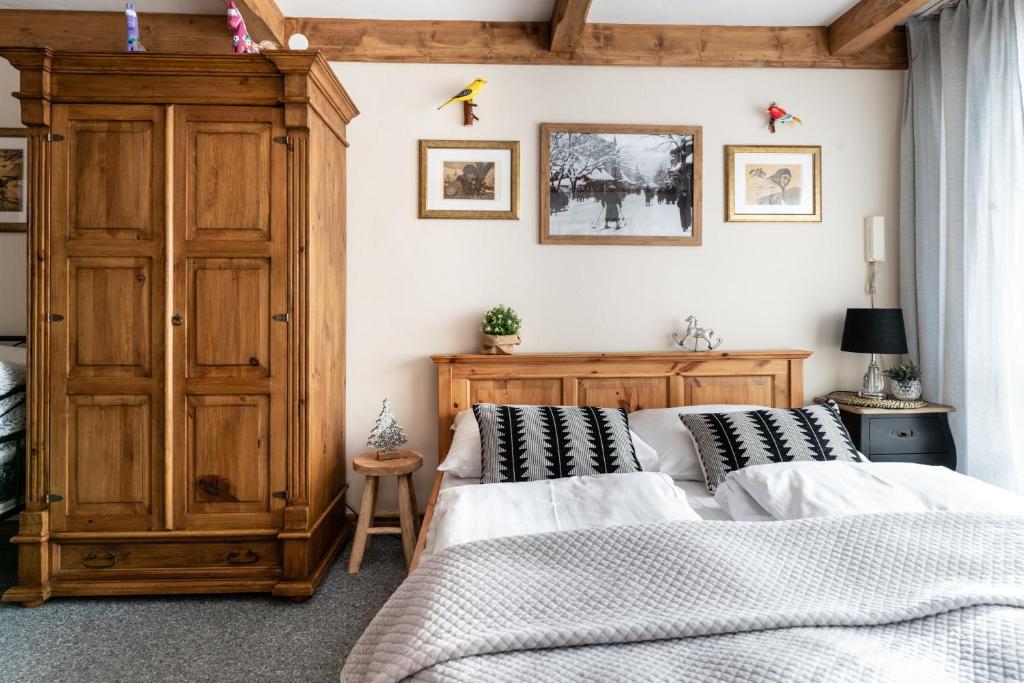 a bedroom with two beds and a wooden cabinet at Górski klimat Apartament in Zakopane