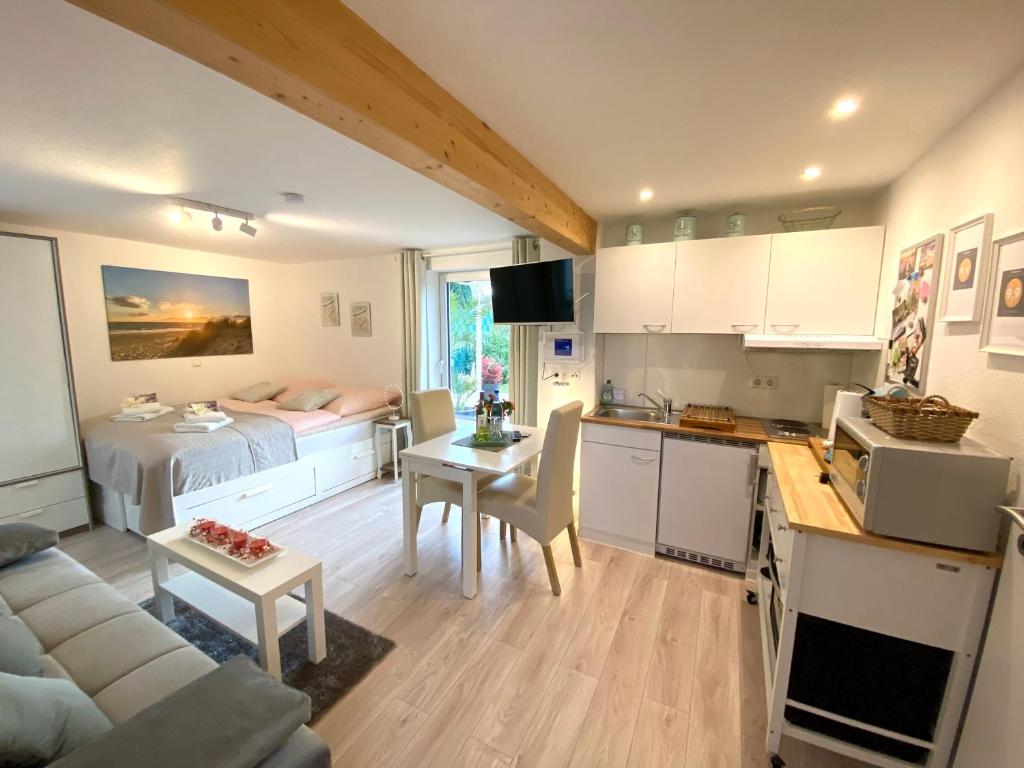 a kitchen and living room with a bed and a table at Apartment Glesch in Bergheim