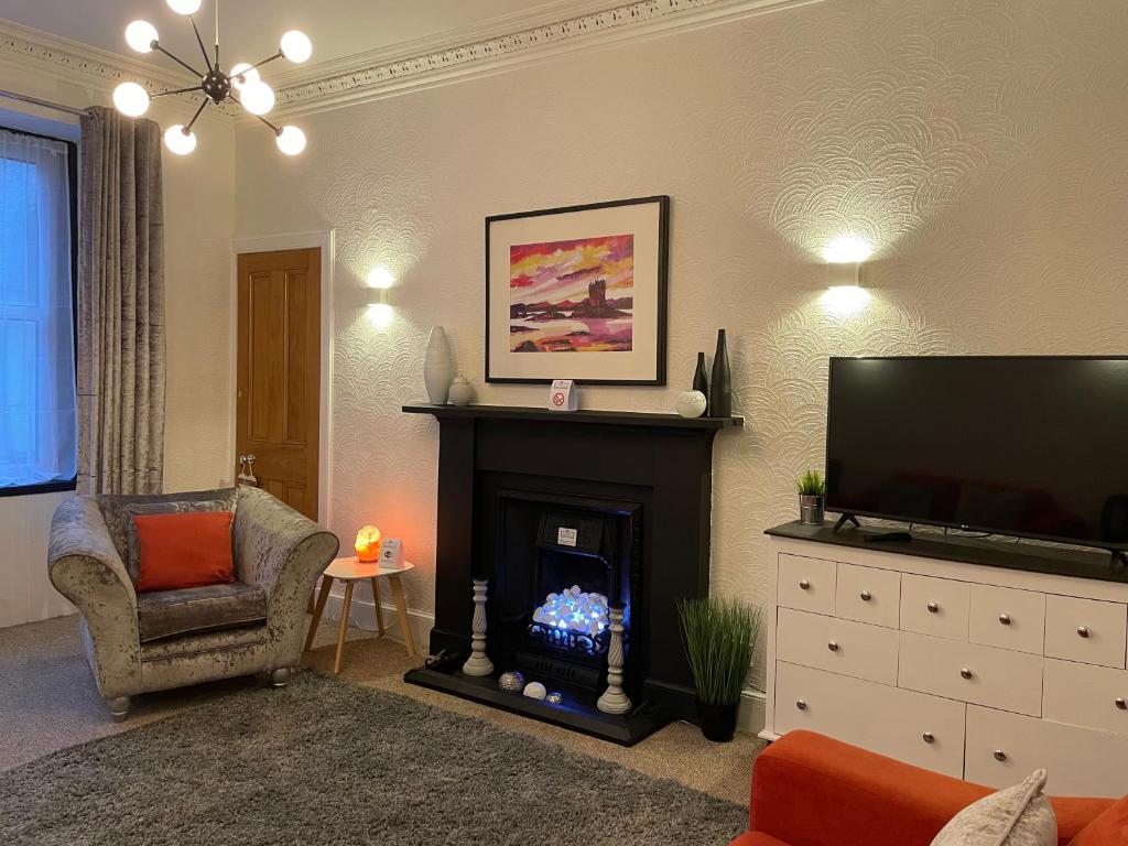 sala de estar con chimenea y TV de pantalla plana en Heart of George street / Oban / Argyll en Oban