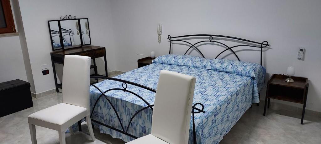 una camera con un letto e due sedie bianche di Il Canaletto a Matino