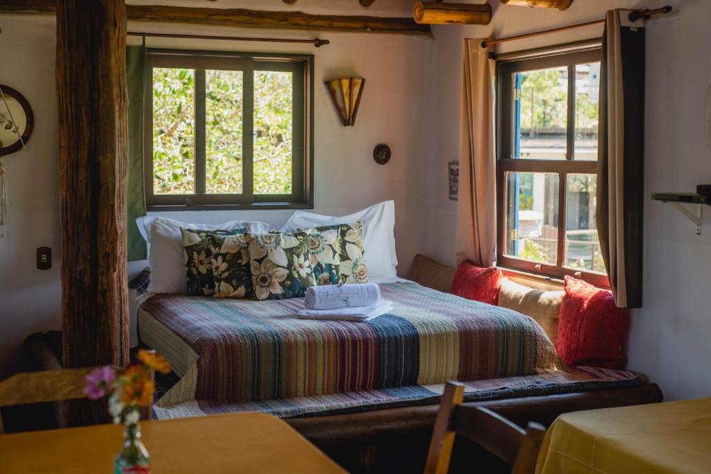 a bedroom with a bed and a window at Pousada Gopak in Praia do Rosa