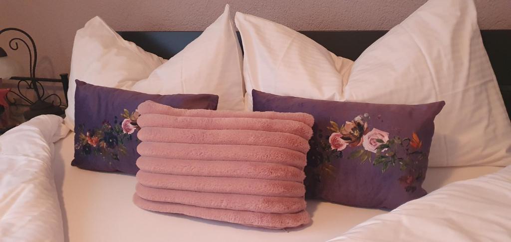 a pile of towels sitting on a bed with pillows at Hotel Rosengärtli in Leissigen
