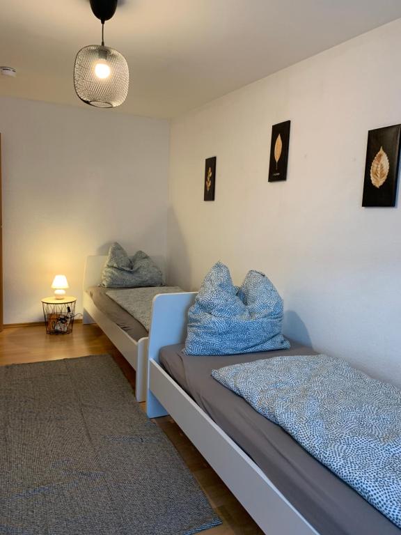 - 2 lits dans une chambre avec des oreillers bleus dans l'établissement Blue Chili 21 - Großzügige Altbauwohnung bis 7 Personen WLAN Balkon, à Magdebourg