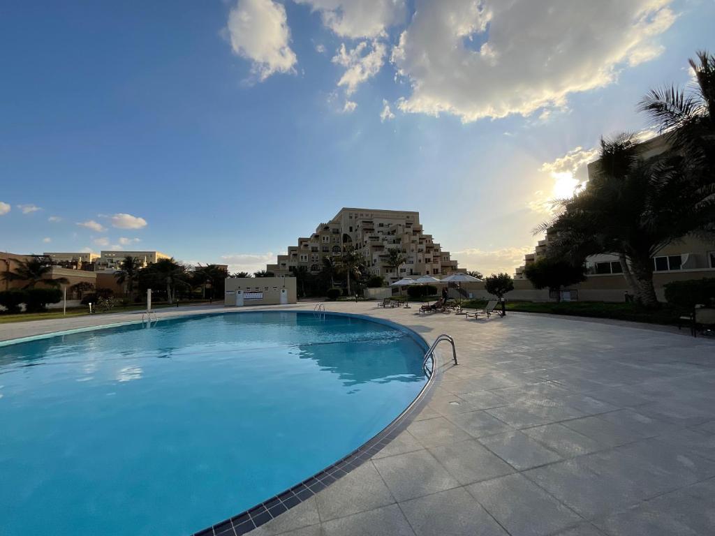 una gran piscina con un edificio en el fondo en Lovely 1 bedroom holiday home on the beach, en Ras al Khaimah