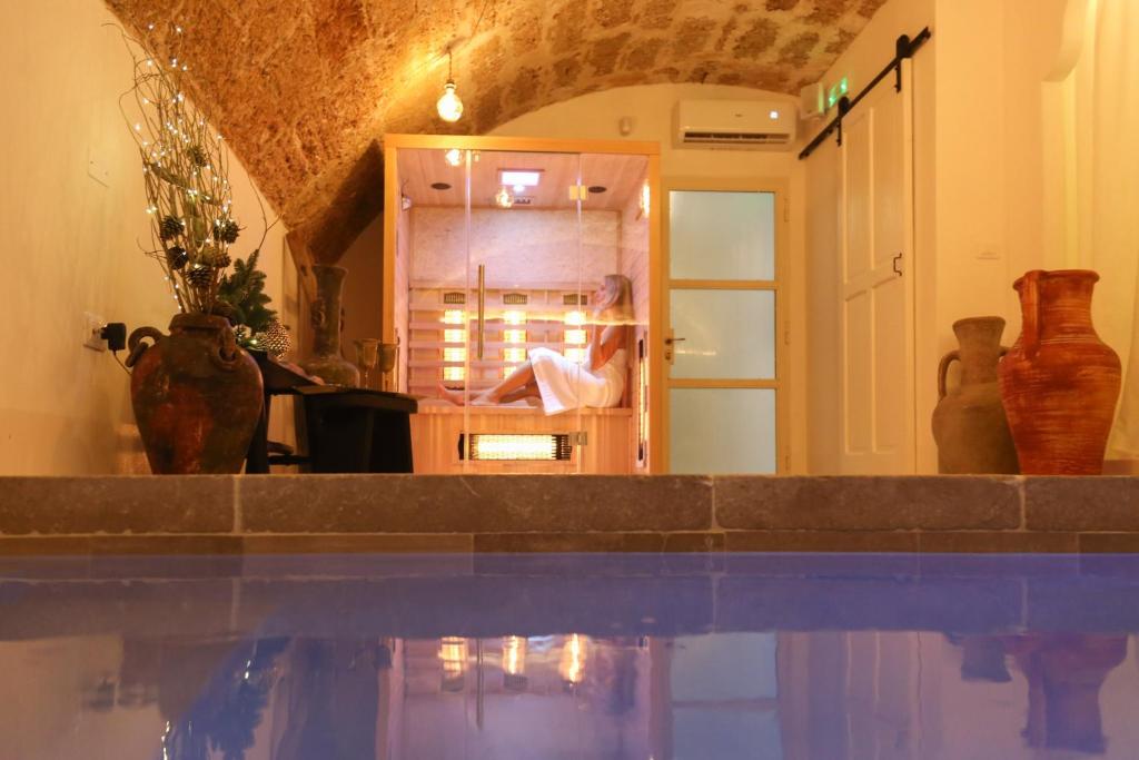 a woman sitting in a mirror in a room with vases at CORTE LARGO LAURO DIMORE & SPA in Gemini