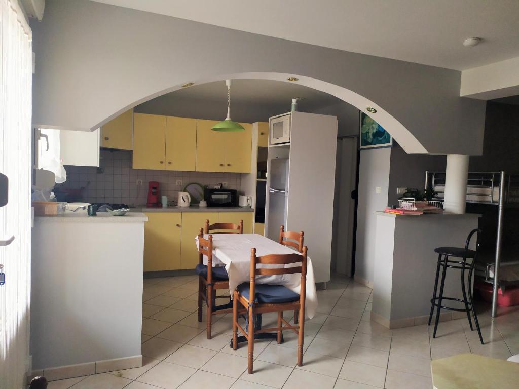 a kitchen with an arch over a table and chairs at Le Trèfle d'Or in Gérardmer