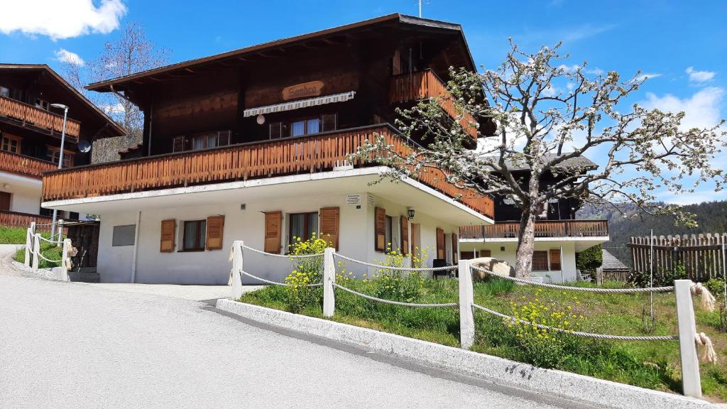 ein Gebäude mit einem Zaun davor in der Unterkunft Haus Sandra in Fiesch